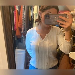 White knit v neck sweater with tassels.